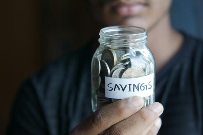 Coins and a savings jar representing an emergency fund
